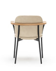 The Solace Dining Armchair by Wooden Stories features a modern beige leather upholstery, curved wooden backrest, and black metal legs, shown from the back against a white background.