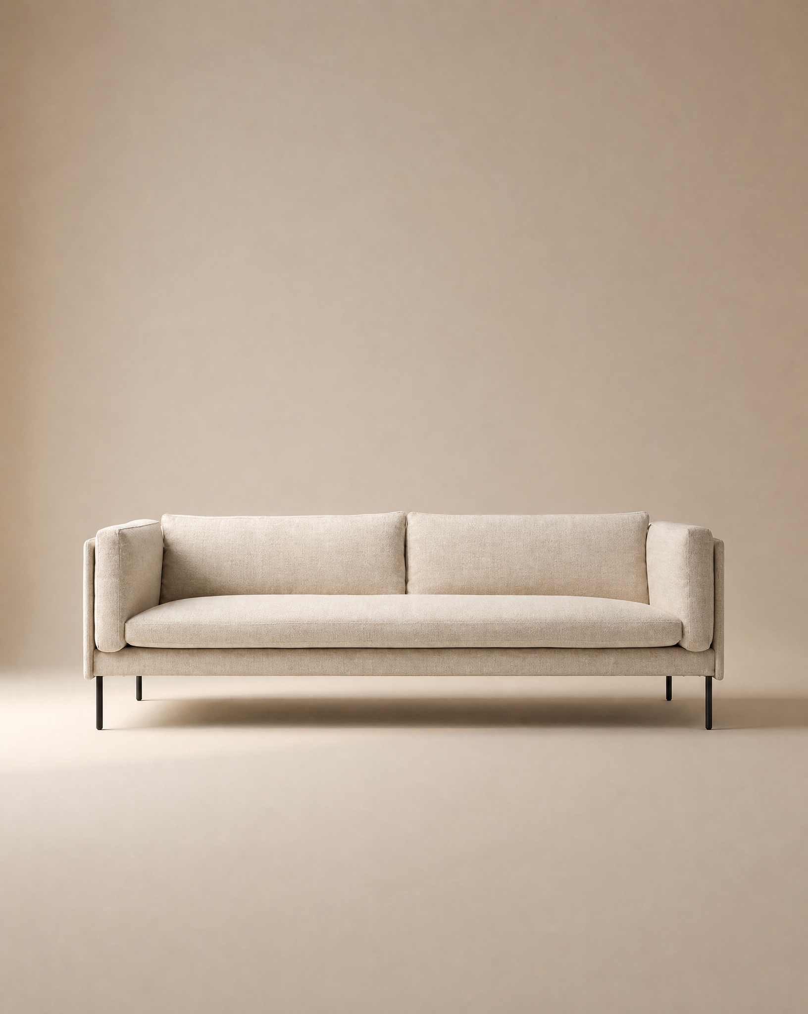The Sonder Sofa | Fabric by Wooden Stories, showcasing Danish-inspired lines, a linear frame, and slim black legs in modern beige upholstery, is centered against a matching beige background to create a minimalist and neutral setting.