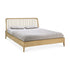 The Ethnicraft Spindle Bed - Oak features a slatted headboard in light European oak, shown with a gray blanket and two matching pillows.