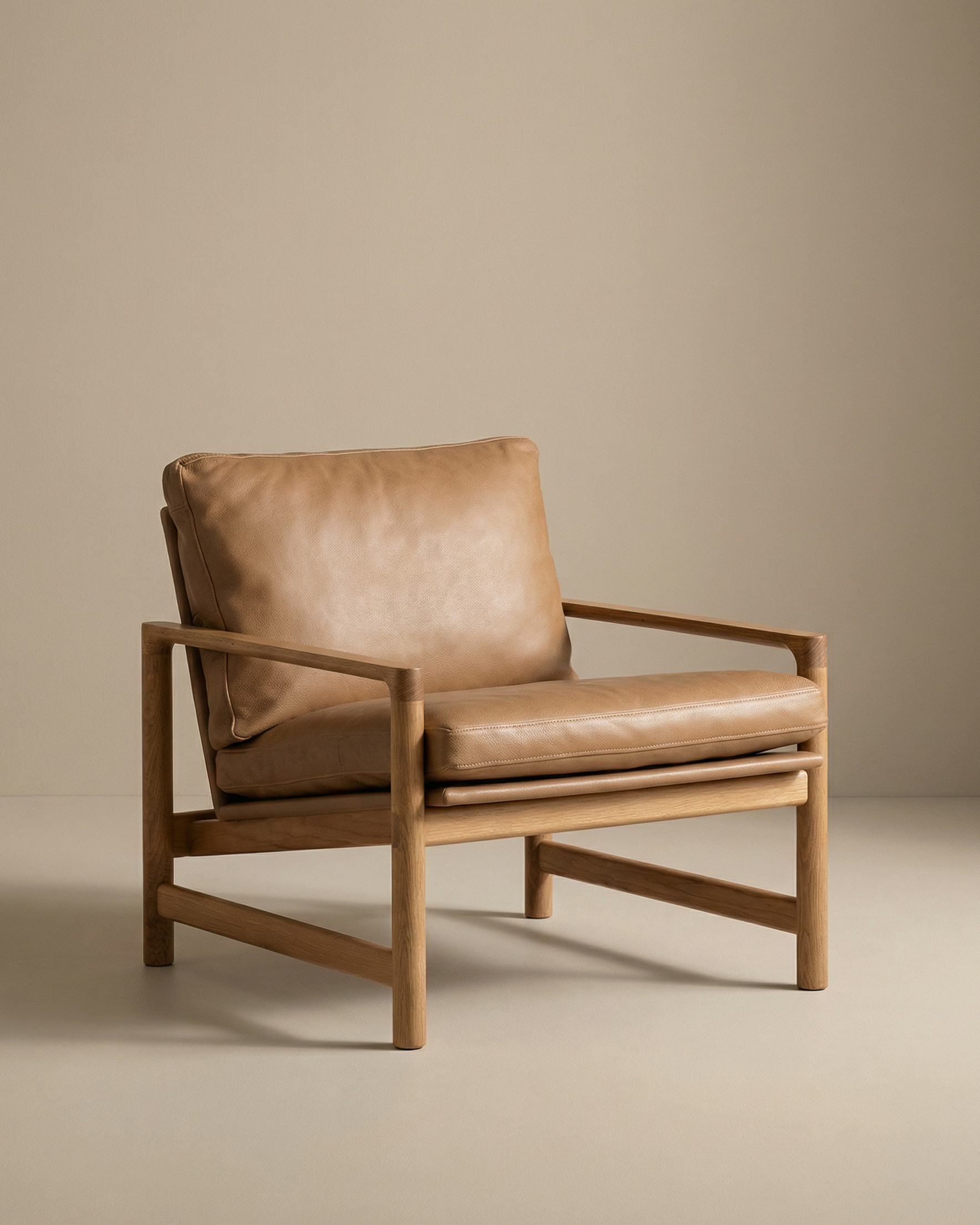 The Troubadour Lounge Chair | Leather by Wooden Stories features a solid oak frame and tan leather cushions. Set against a beige background, its minimalist design takes inspiration from Danish collections with clean lines and neutral tones.