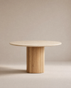 The Tathra Round Dining Table by Wooden Stories features a stone top, a thick cylindrical base, and minimalist design set against a beige background—perfect as a contract grade piece for versatile spaces.