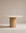 The Tathra Round Dining Table by Wooden Stories features a stone top, a thick cylindrical base, and minimalist design set against a beige background—perfect as a contract grade piece for versatile spaces.