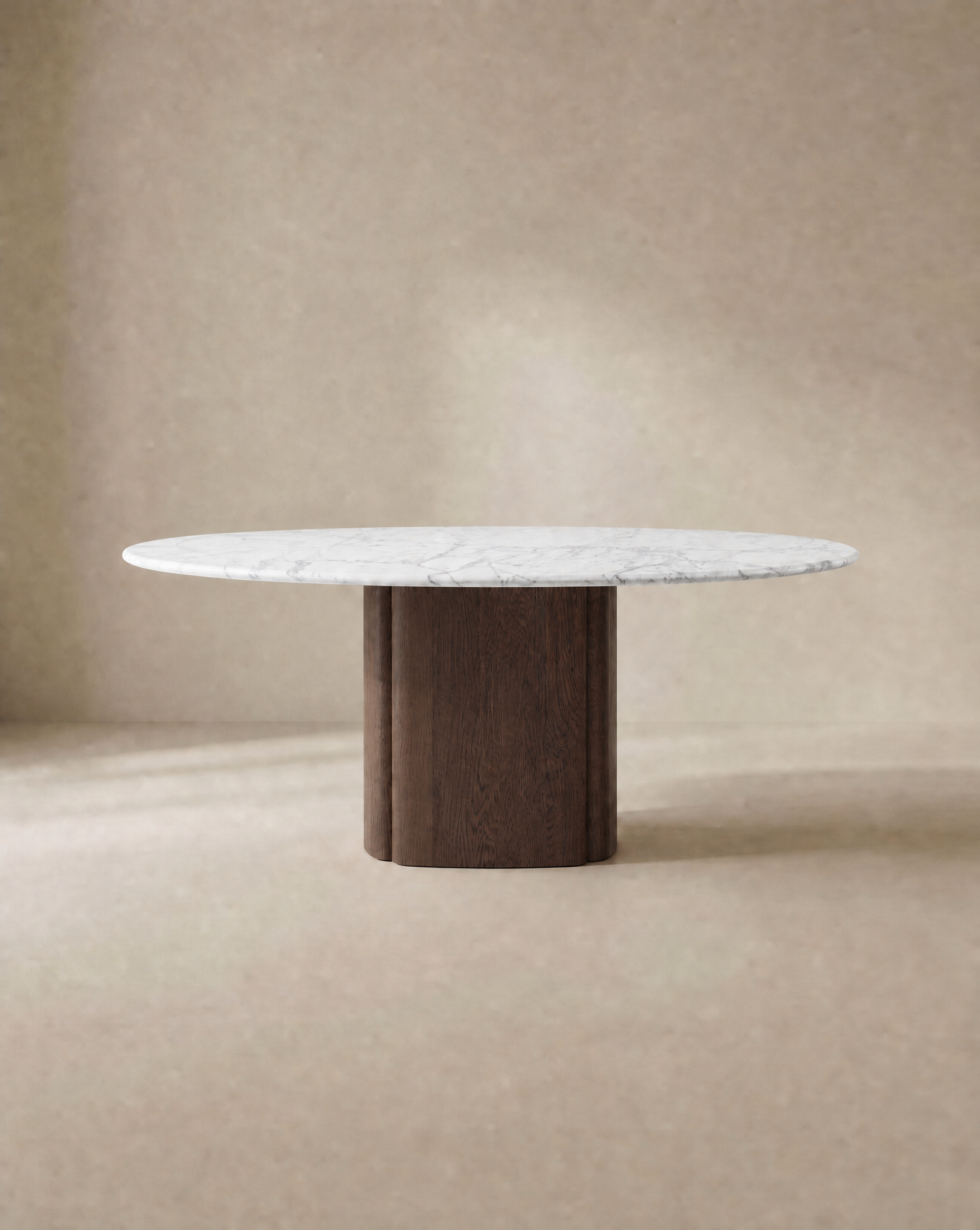The Tathra Round Dining Table | Stone Top by Wooden Stories features a white marble top and wide solid oak pedestal base, set against a neutral beige background. Its minimalist, modern design is contract grade for lasting durability.