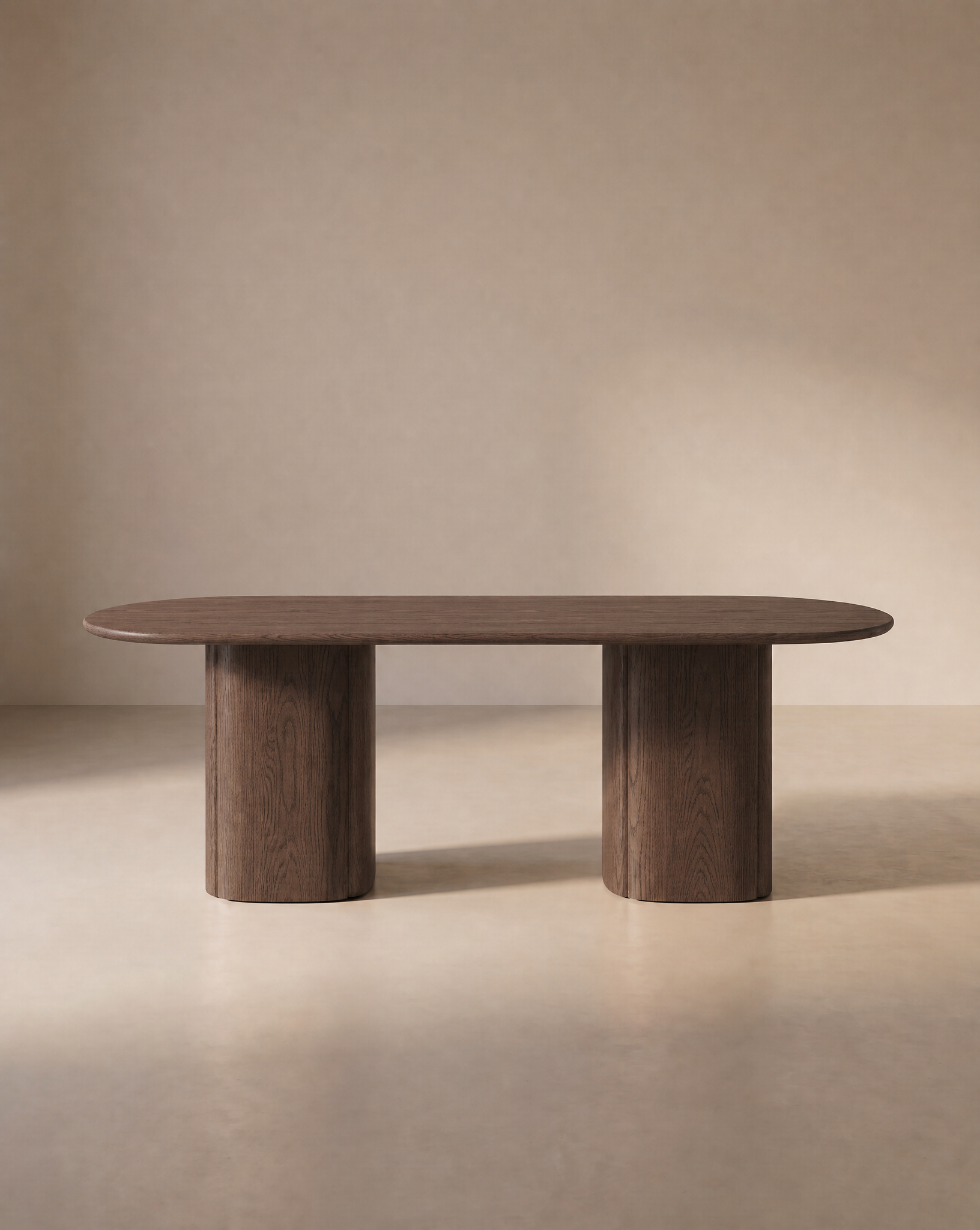 The Tathra Ellipse Dining Table by Wooden Stories features a modern oval shape crafted from oak, reminiscent of Danish design, with a smooth surface and two cylindrical pedestal legs, elegantly set against a neutral beige background.