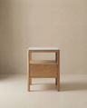 The Theo Nightstand by Wooden Stories features a modern wooden build, marble top, Danish lines, and a single drawer in a minimalist design. Shown against a plain beige background.