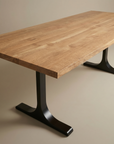 The SOBU Tommaso Dining Table features a modern rectangular solid wood top with a smooth, light wood grain surface and two black metal T-shaped legs, shown on a neutral-colored floor.