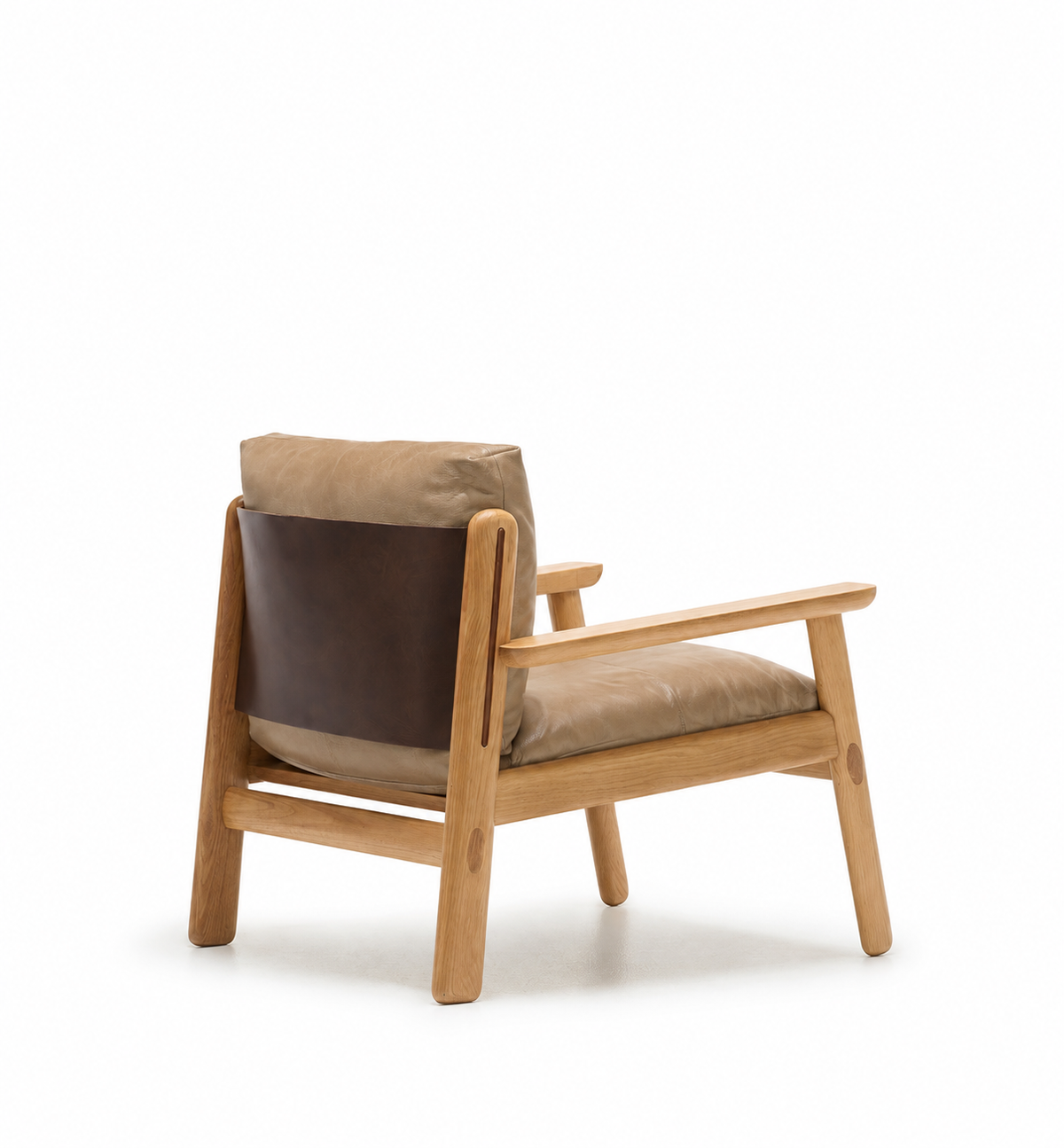 The Wren Lounge Chair | Leather by Wooden Stories features tan leather cushions and a dark brown leather backrest, all beautifully crafted from solid walnut. Shown from an angled rear view against a white background, this chair evokes the timeless elegance of classic Danish furniture.