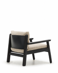 The Wren Lounge Chair | Fabric by Wooden Stories features a solid walnut frame, light beige cushions, and a curved black backrest panel that evoke the classic elegance of Danish design, shown here against a white background.
