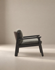 The Wren Lounge Chair | Fabric by Wooden Stories, featuring a solid walnut frame and gray upholstered seat and backrest, is photographed from the side against a plain beige background, evoking the timeless elegance of Danish design.
