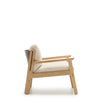 Side view of the Wren Lounge Chair | Fabric by Wooden Stories, a modern wooden armchair inspired by Danish design, featuring a solid walnut frame and light beige cushioned seat and backrest, set against a plain white background.