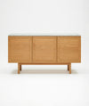 The Yorke Sideboard with Stone Top by Wooden Stories features Danish-inspired lines and three panel doors, topped with white stone, shown against a plain white background.