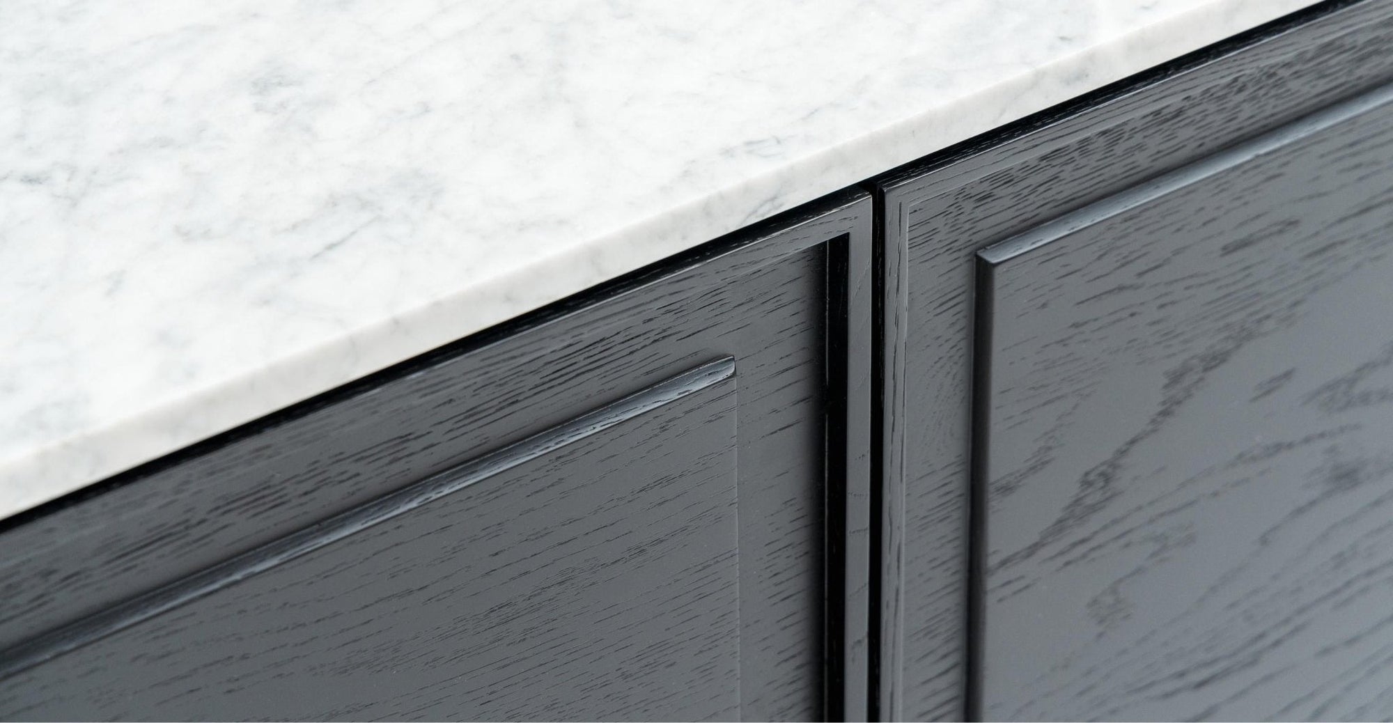 Close-up of the Wooden Stories Yorke Sideboard with Stone Top. Its gray finish, visible wood grain, and flat-panel design offer sleek Danish lines for a minimalist, contemporary look.