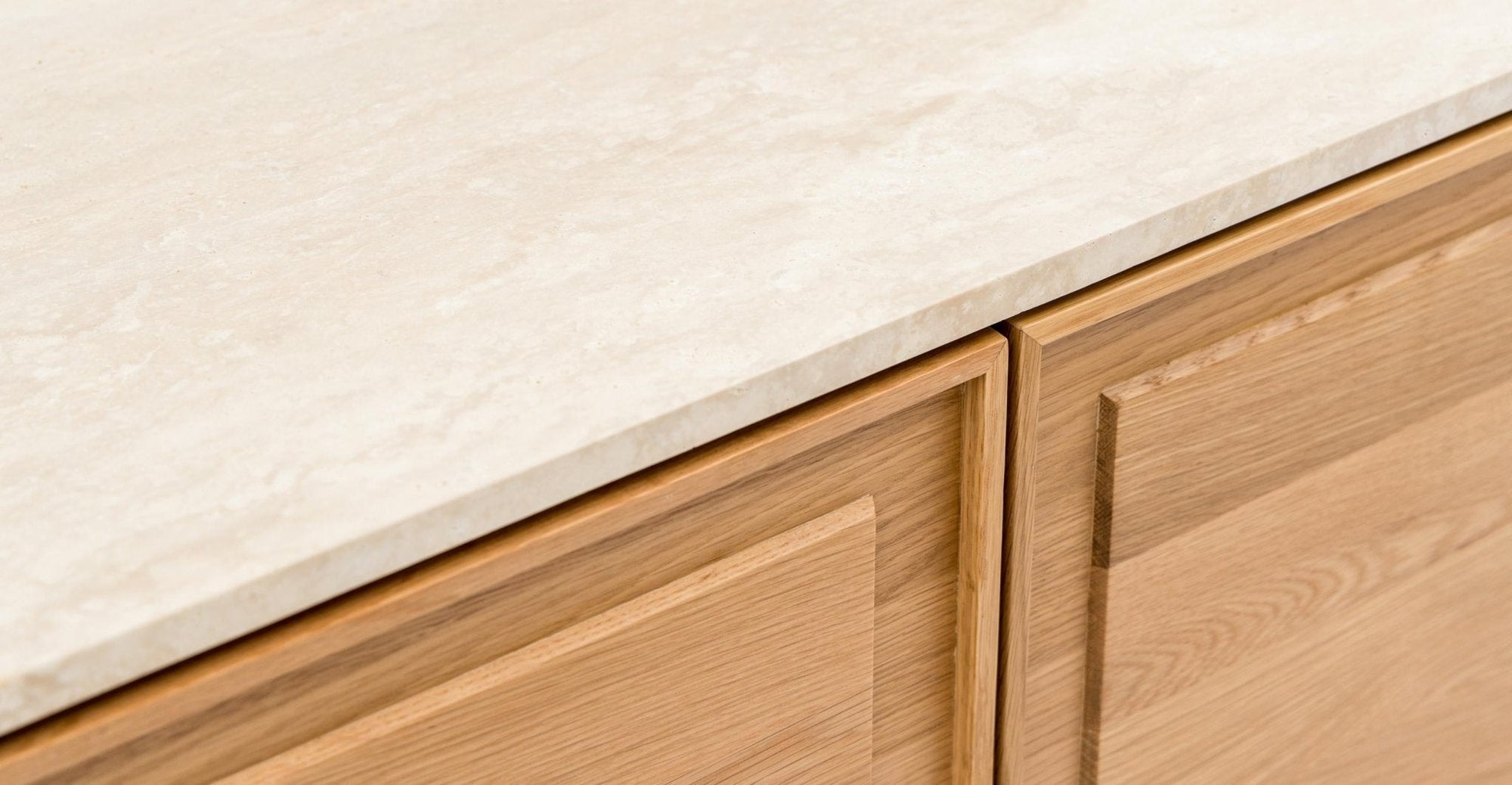 Close-up of the Wooden Stories Yorke Sideboard with Stone Top, featuring a light stone surface and natural-finish cabinetry with simple rectangular paneling.