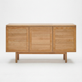 The Yorke Sideboard by Wooden Stories is a minimalist solid oak piece with three doors, a light natural finish, and Scandinavian design. It stands on four sturdy legs and is pictured against a plain white background.