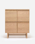 The Yorke Highboard by Wooden Stories features a minimalist, light wood design with four panel doors, clean lines, and stands on a matching wooden frame against a plain white background.