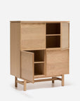 The Yorke Highboard by Wooden Stories is a light wood Danish cabinet with four compartments—two open shelves, two with partially open doors—and stands on four short legs with a crossbar, exemplifying classic Scandinavian design.
