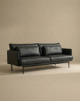 The SOBU Cherry Sofa | Leather is a modern black leather 3-seater with Danish lines, slim metal legs, and two seat cushions—ideal for contemporary living spaces and shown against a plain beige background.