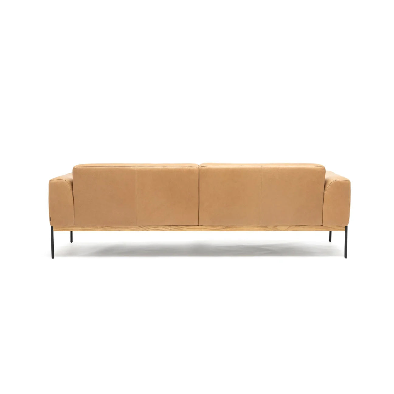 The Department Sofa 93&quot; by Wooden Stories features modern tan leather upholstery, Danish lines, square arms, and slim black metal legs atop a solid wood plinth, shown from the back against a plain white background.