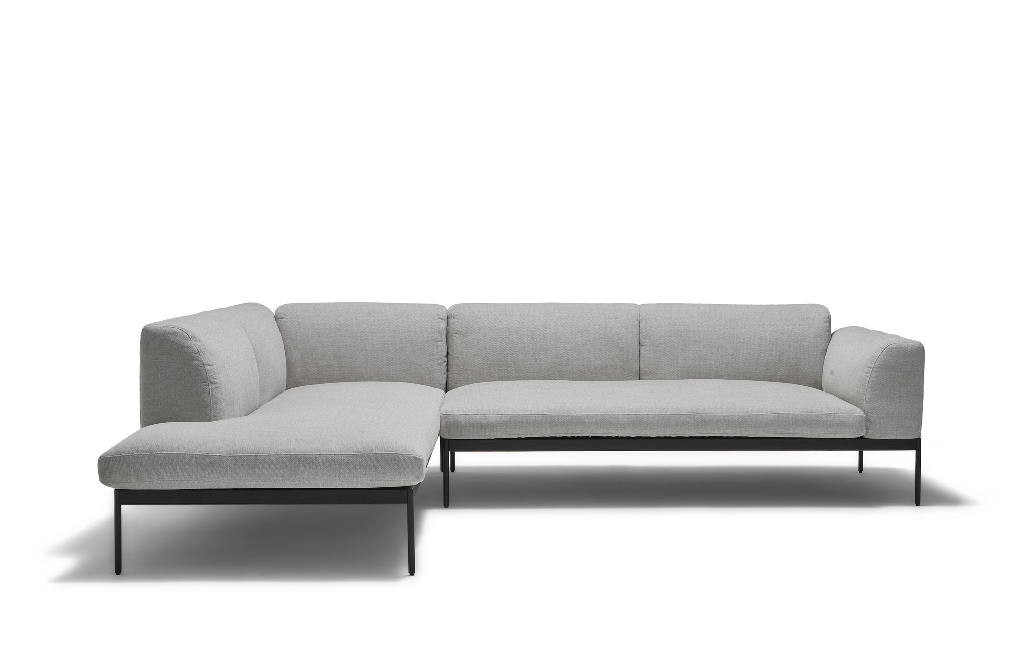 The Wooden Stories Department Modular Sofa | Fabric • M6 Left is a modern, light gray L-shaped piece with slim black metal legs and an FSC-certified oak solid wood base, shown against a plain white background.