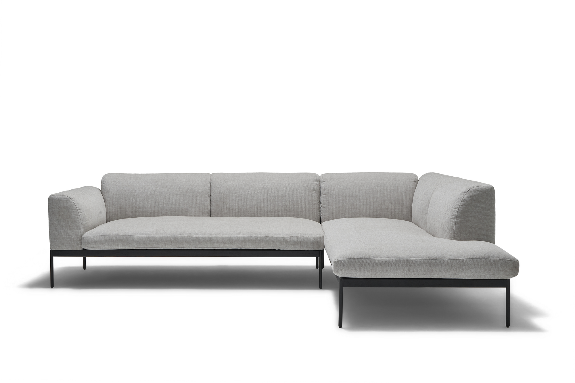 The Department Modular Sofa | Fabric · M6 Right by Wooden Stories is a modern, light gray L-shaped sectional with a solid wood base, slim black metal legs, tufted seats, plush backrests, and Danish-inspired design against a white background.