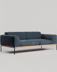 The Wooden Stories Department Sofa 81" | Fabric features a modern dark blue design with Danish lines, a solid wood plinth base, and slim black metal legs, shown against a plain light gray background.