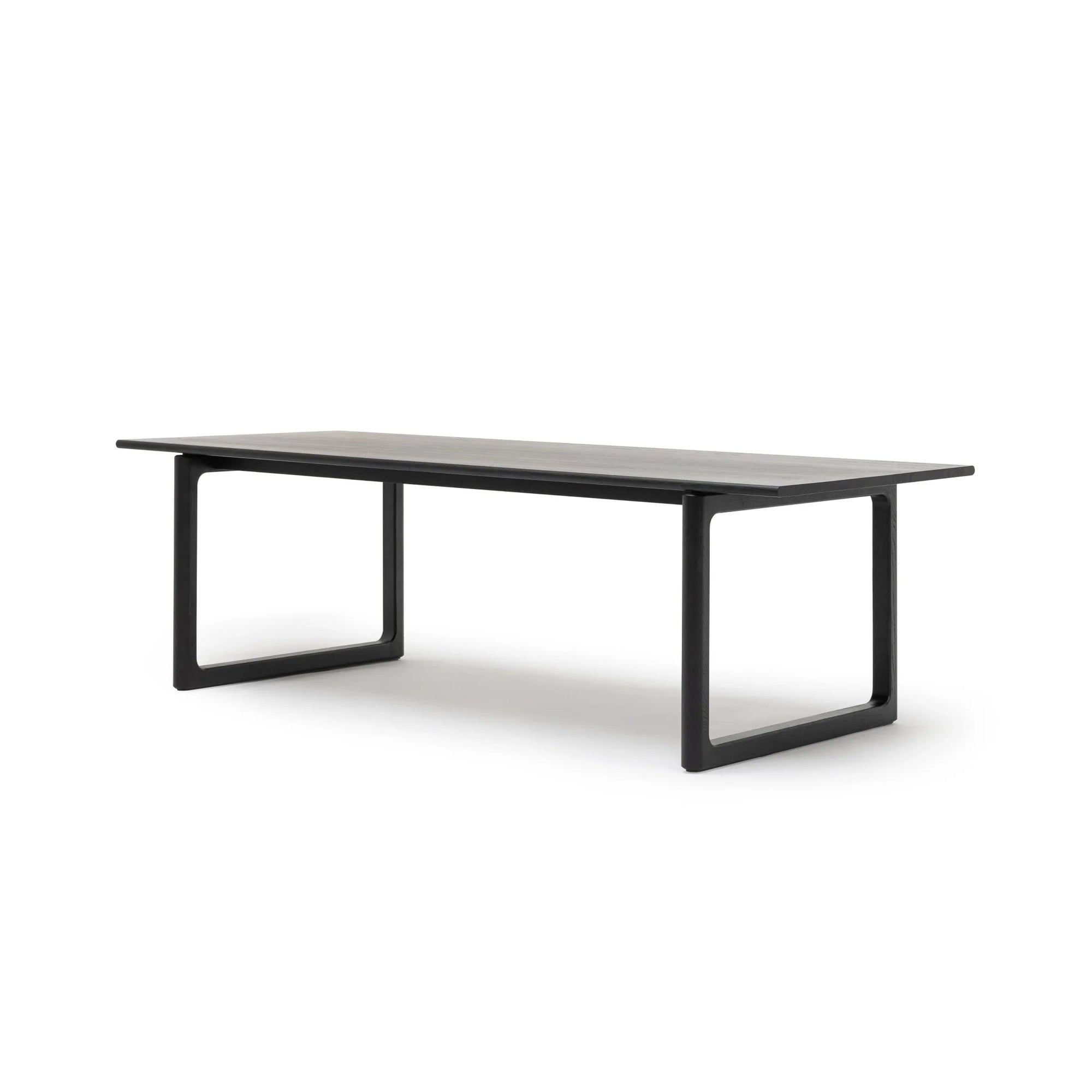 The Hover Dining Table | Black Oak by Wooden Stories is a modern rectangular table with Danish lines, flat top, and open rectangular legs—ideal for elevating dining room decor, shown against a plain white background.