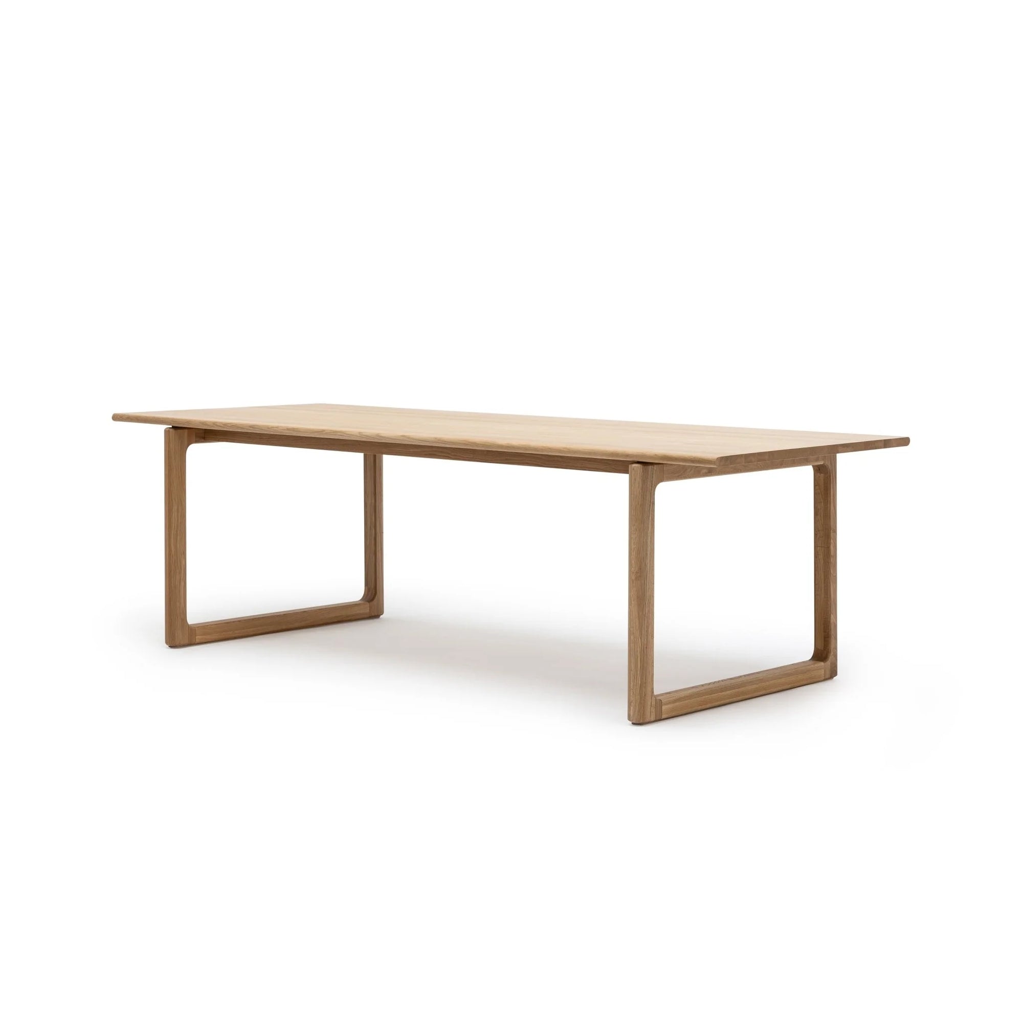 The Hover Dining Table | Light Oak by Wooden Stories features modern Danish lines, a light oak finish, and open-frame legs—an elegant addition to any dining room, shown here against a plain white background.