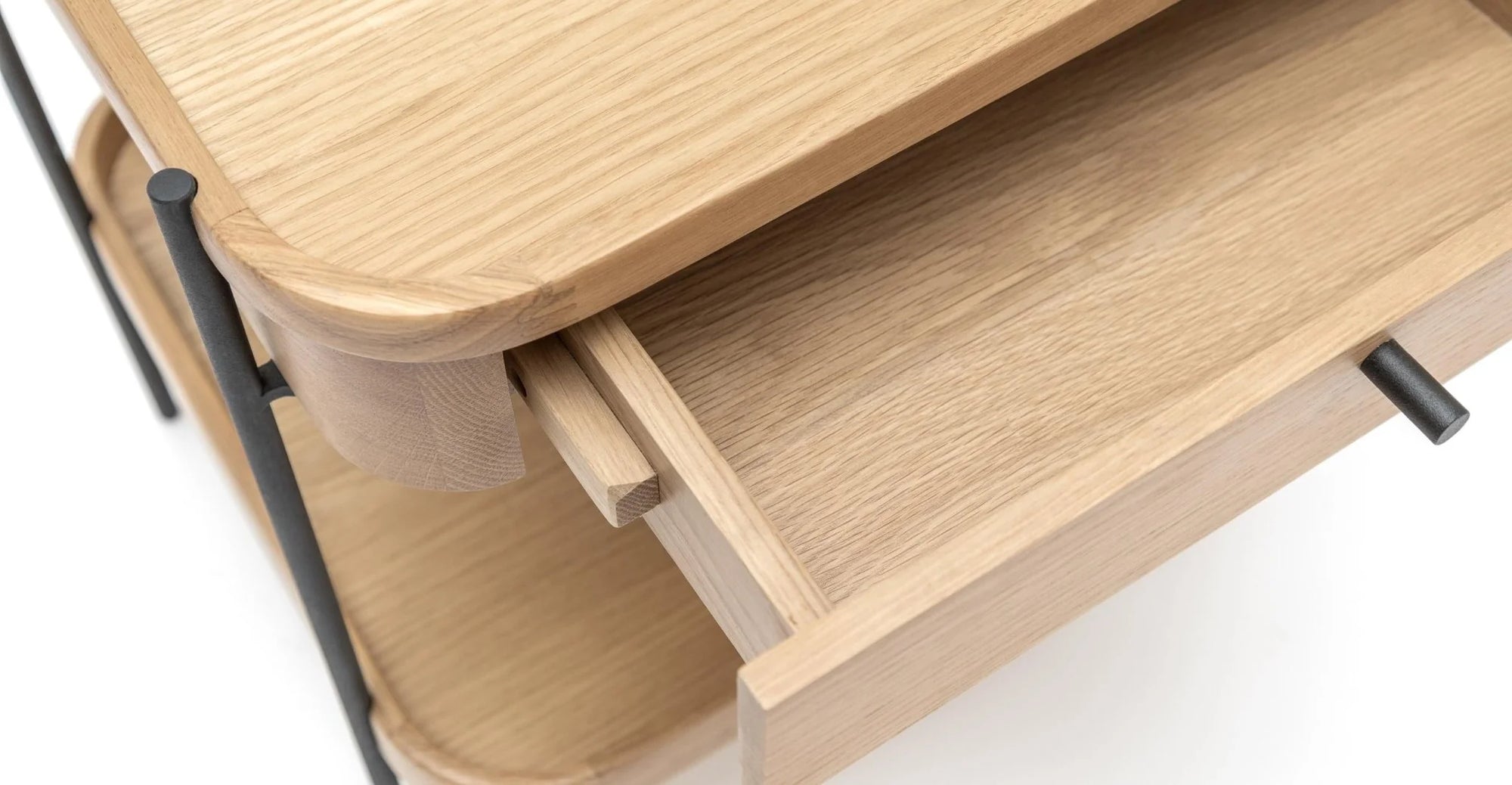 Close-up of the Wooden Stories Humla Side Table With Storage—a light solid wood table with rounded edges, an open drawer with a black handle, visible wood grain, and sleek black metal legs.
