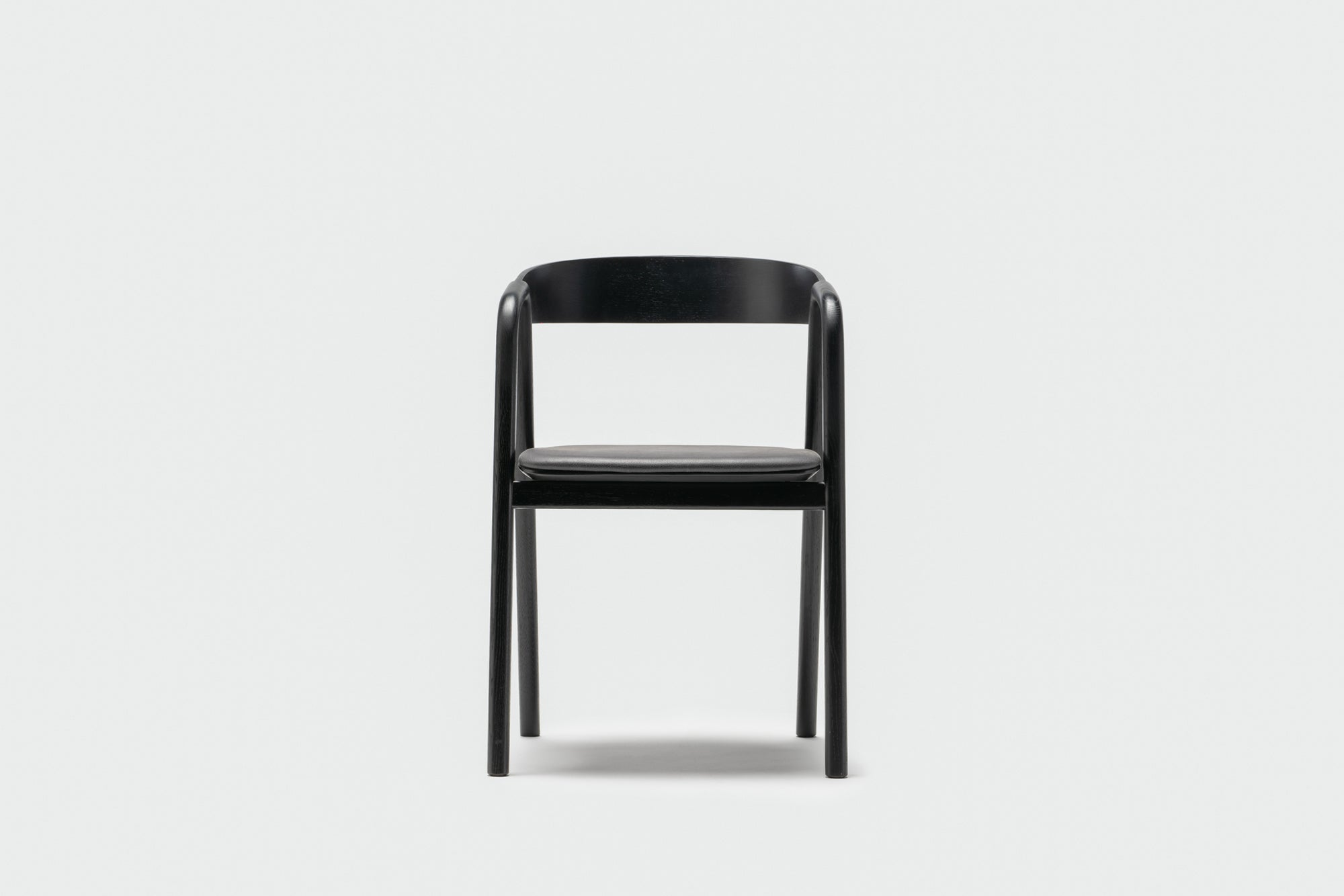 The Wooden Stories Inlay Dining Chair | Black Oak and Leather is a minimalist chair with a plywood backrest and four straight legs, shown against a plain white background.