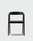 The Wooden Stories Inlay Dining Chair | Black Oak and Leather is a minimalist chair with a plywood backrest and four straight legs, shown against a plain white background.