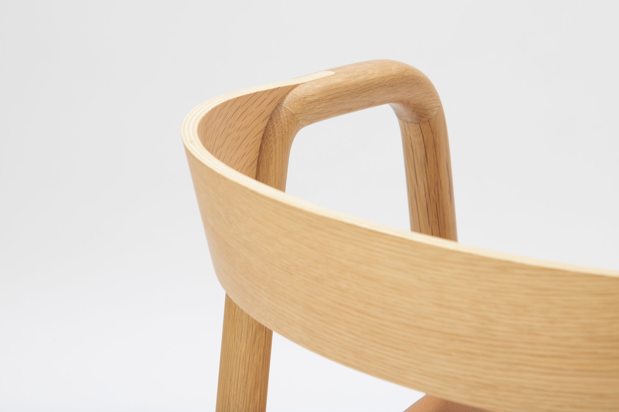 Close-up of the Wooden Stories Inlay Dining Chair | Light Oak, highlighting its curved plywood backrest and smooth light oak grain, set against a plain white background.