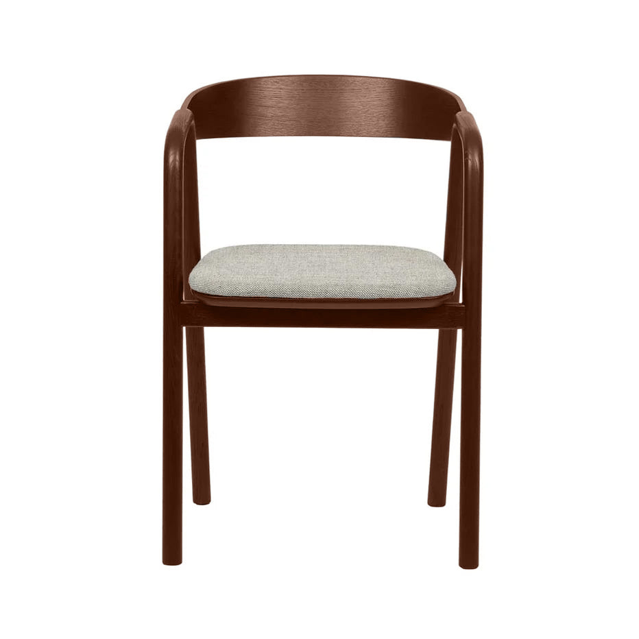 The Inlay Dining Chair by Wooden Stories features an espresso oak frame, curved backrest and armrests, and a light gray upholstered seat. This modern piece from the Danish Collection is shown against a white background.