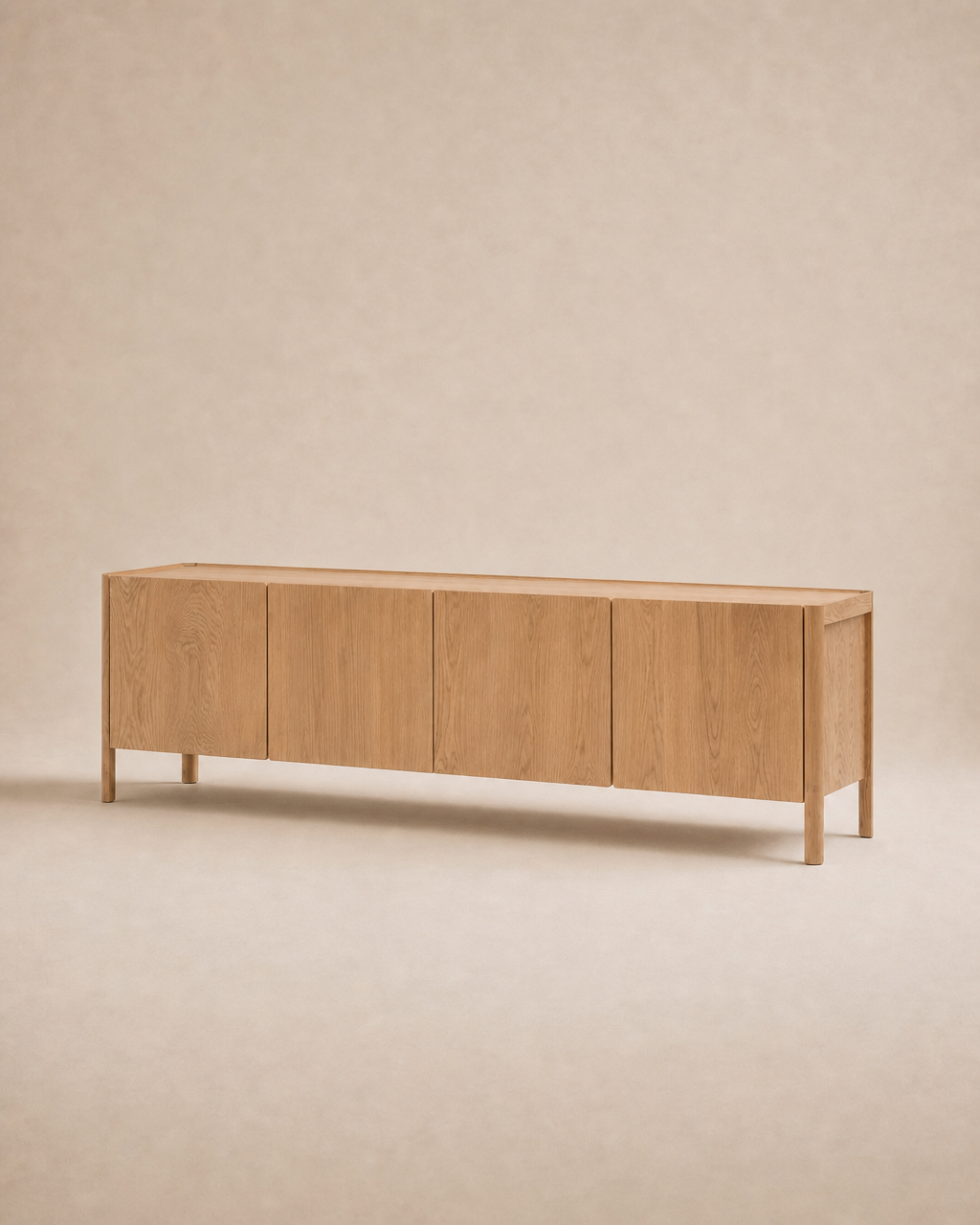 The Nell Sideboard | Light Oak by Wooden Stories features a long, minimalist Scandinavian design with four cabinet doors, crafted from solid oak and photographed against a neutral beige background.