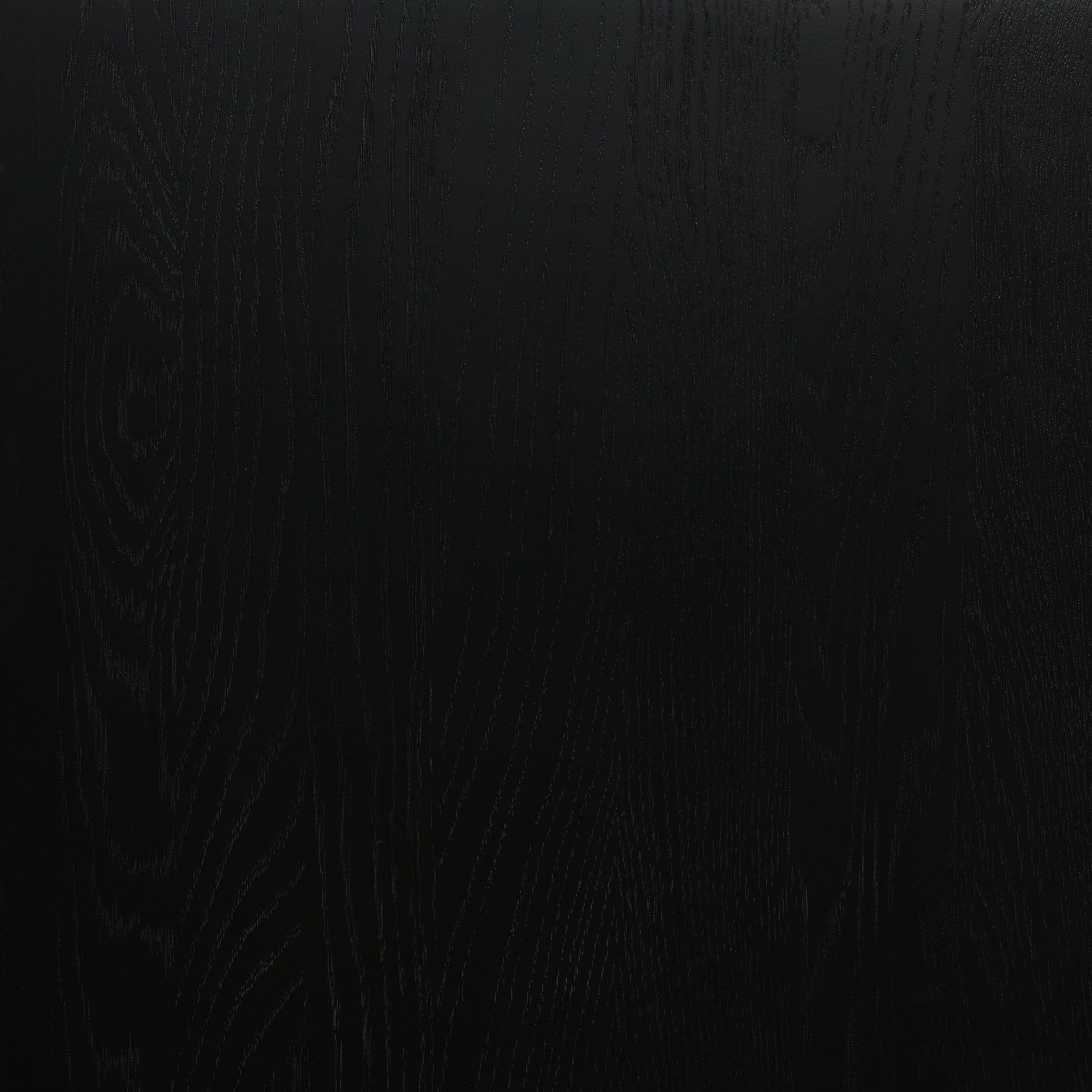 A black wooden surface with subtle grain offers an ideal backdrop for displaying Material Swatches from the Natadora + Tolv collection.