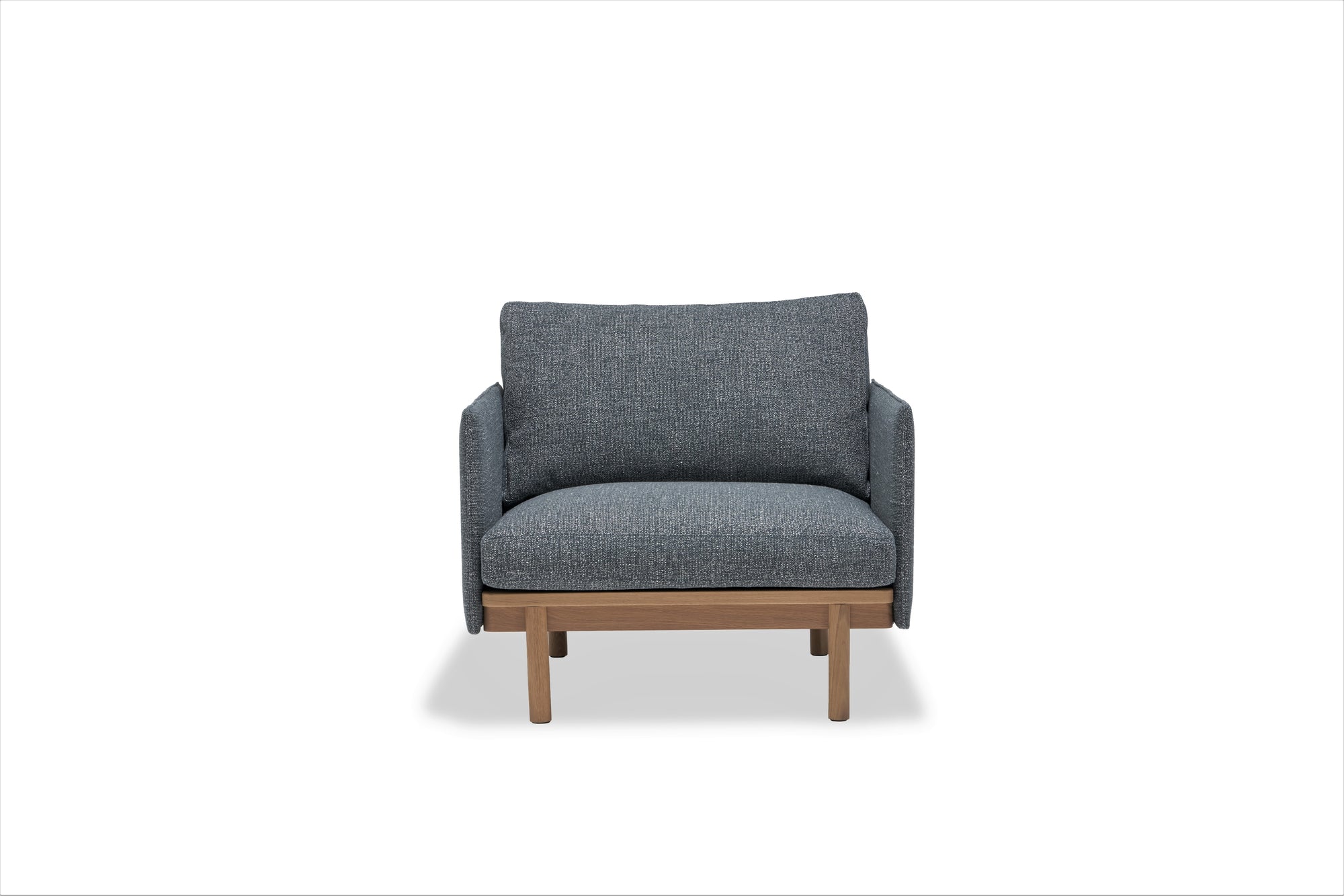The Pensive Lounge Chair | Fabric by Wooden Stories features blue-gray upholstery, wooden legs, and elegant Danish-inspired lines in a simple boxy design, shown against a plain white background.