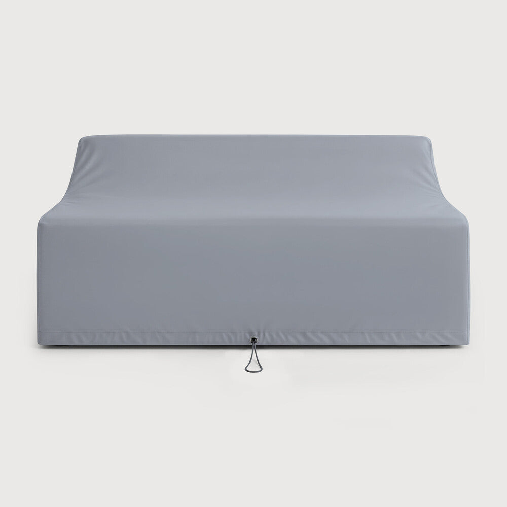 A gray Rain Cover - Jack Outdoor Sofa 2 Seater by Ethnicraft is fitted over a modern teak outdoor sofa, featuring smooth, clean lines and a discreet pull loop at the bottom center for easy removal—offering the superior protection you'd expect from premium Ethnicraft outdoor furniture covers.