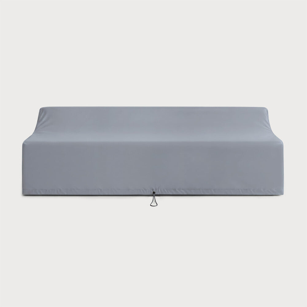A grey, fitted Rain Cover - Jack Outdoor Sofa 3 Seater by Ethnicraft is elegantly draped over a rectangular outdoor sofa. Designed with clean lines and featuring a small pull loop at the bottom center, this cover embodies the functionality and quality expected from premium outdoor furniture rain covers. The background is plain white.