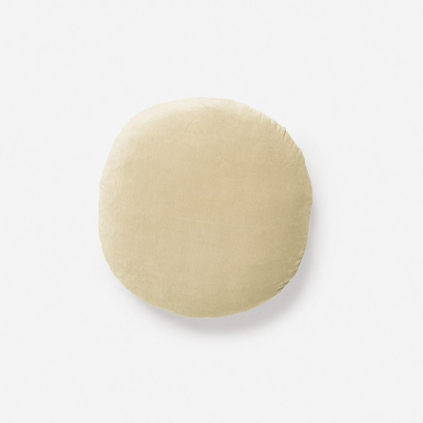 The CITTA Velvet Round Cushion in Custard features a soft, smooth light beige velvet texture and is shown against a plain white background.