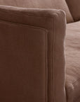 Close-up of the armrest and cushion of the Sonder Sofa | Fabric by Wooden Stories in brown fabric, showcasing its soft texture and precise stitching details.