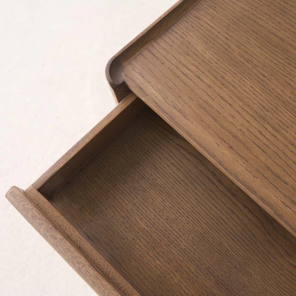 A close-up view of the Wooden Stories Nell Console in Latte Oak, with the wooden drawer partially open to highlight the beautiful grain pattern on both the drawer front and the top—an elegant example of Scandinavian-inspired solid oak craftsmanship.