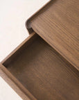 A close-up view of the Wooden Stories Nell Console in Latte Oak, with the wooden drawer partially open to highlight the beautiful grain pattern on both the drawer front and the top—an elegant example of Scandinavian-inspired solid oak craftsmanship.