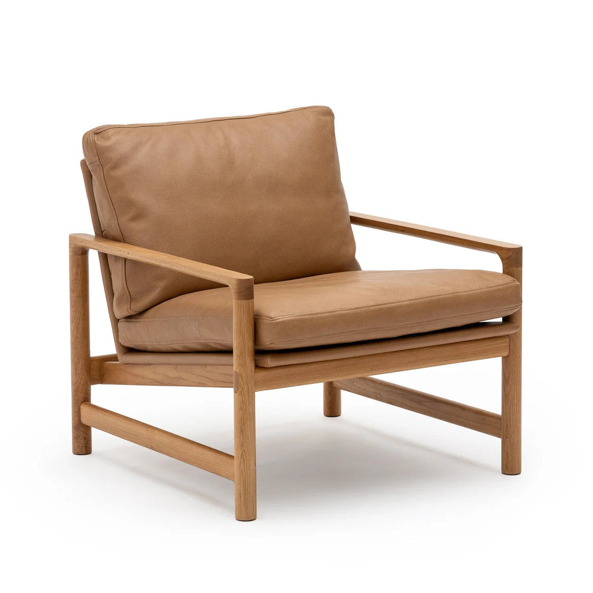 The Troubadour Lounge Chair by Wooden Stories features a light solid oak frame and tan leather seat and backrest cushions, inspired by Danish design, shown isolated on a white background.