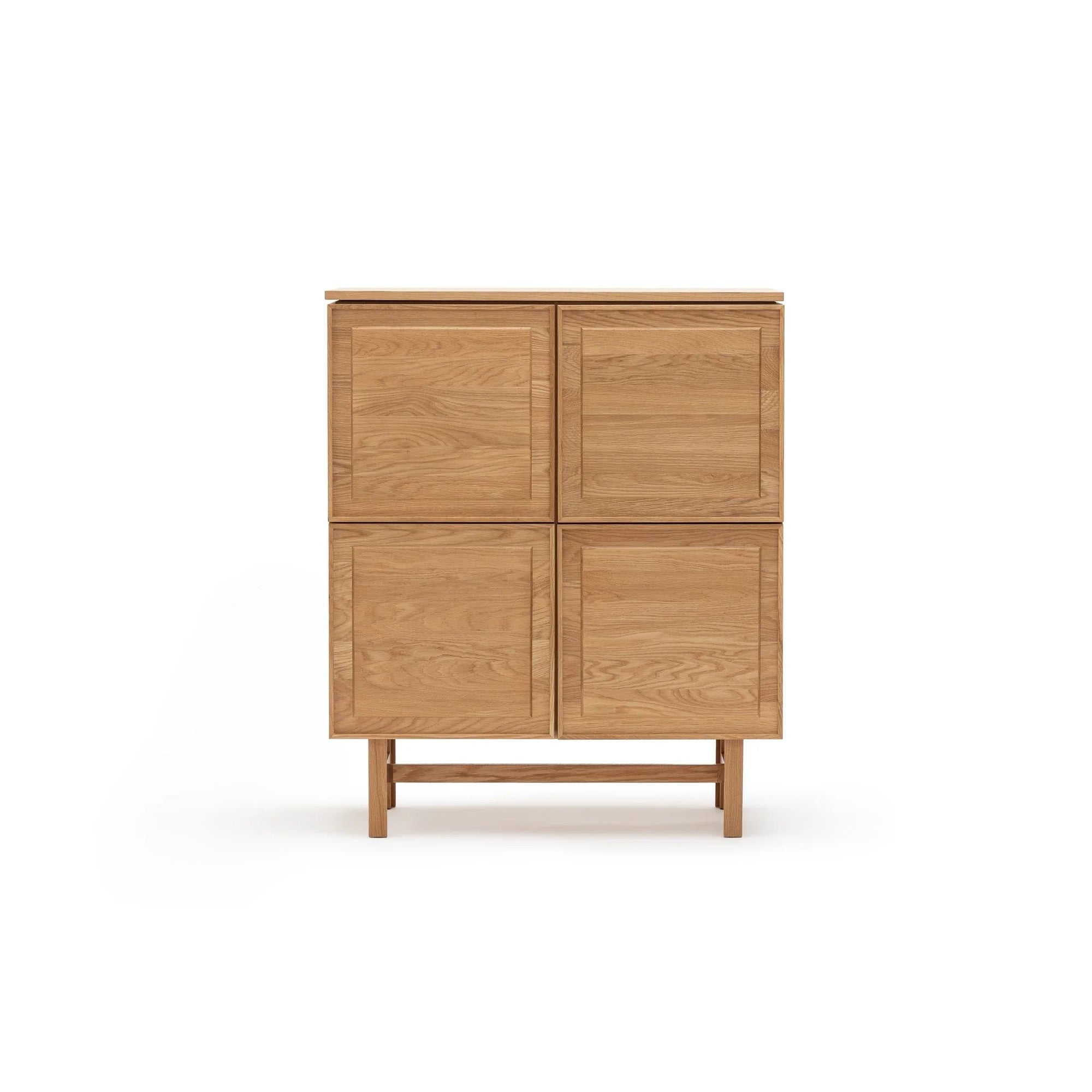 The Yorke Highboard by Wooden Stories features four square doors, a flat top, and a simple frame on short legs, standing against a white background and showcasing timeless Danish design elegance.