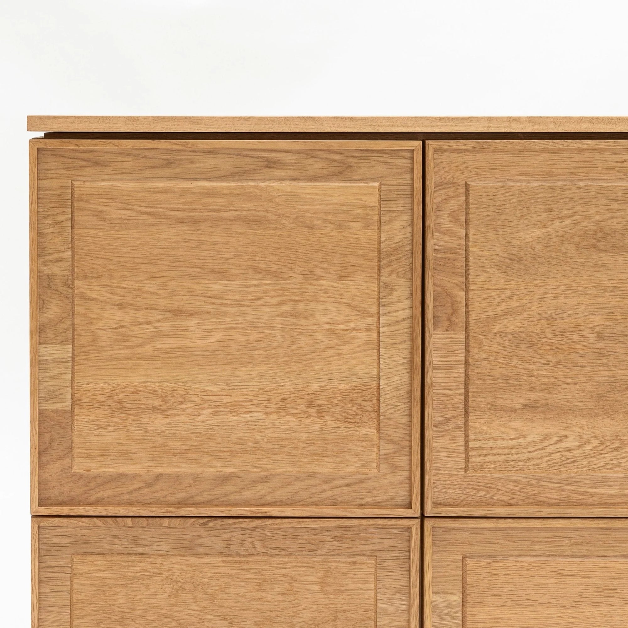 A close-up of the Yorke Highboard by Wooden Stories—a minimalist cabinet with four square doors, light natural wood finish, and sleek panel detailing—showcasing Danish design elegance against a plain white background.
